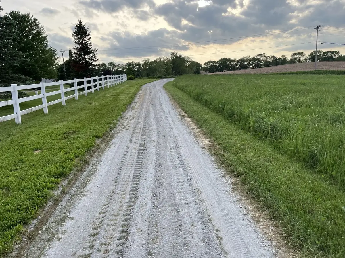 Long completed gravel driveway extending through an open residential property