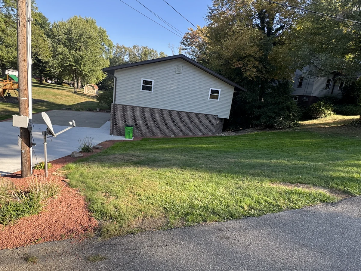 Established grass and finished decorative stone edging beside an existing driveway